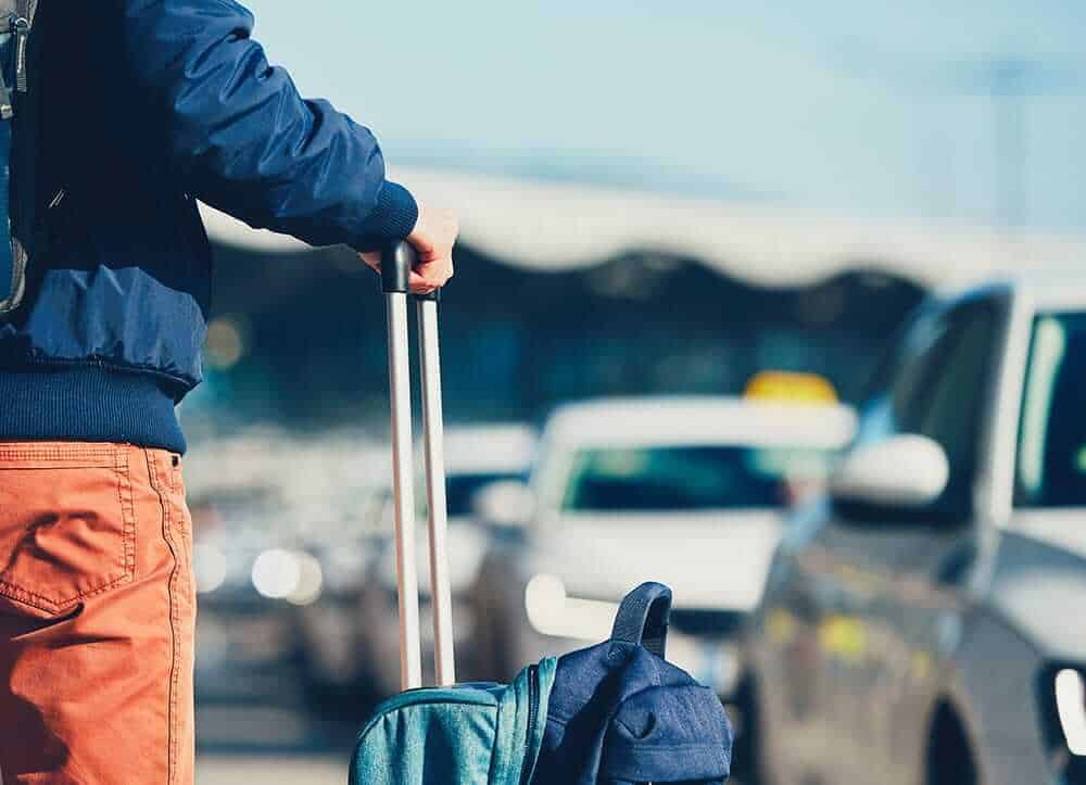 traveler waiting with luggage for taxi