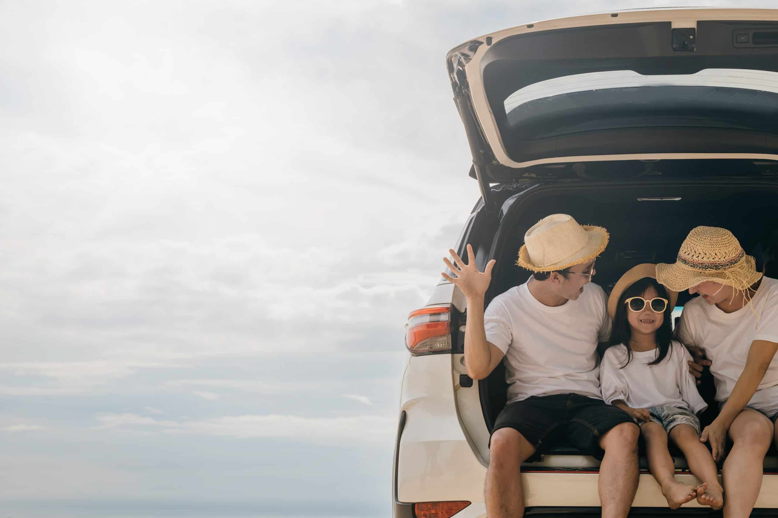 Family sitting on back of car