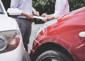 A car accident involving a red and a white vehicle, highlighting insurance claim procedures and accident reporting.